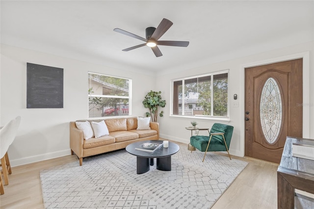 living room featuring light hardwood / wood-style floors, ceiling fan, and a healthy amount of sunlight