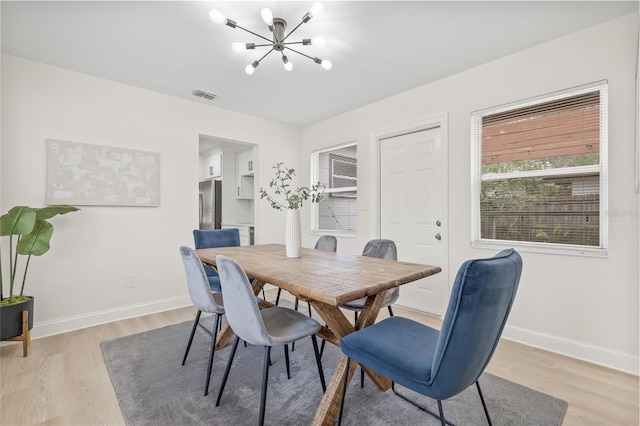 dining room featuring a notable chandelier and light wood-type flooring