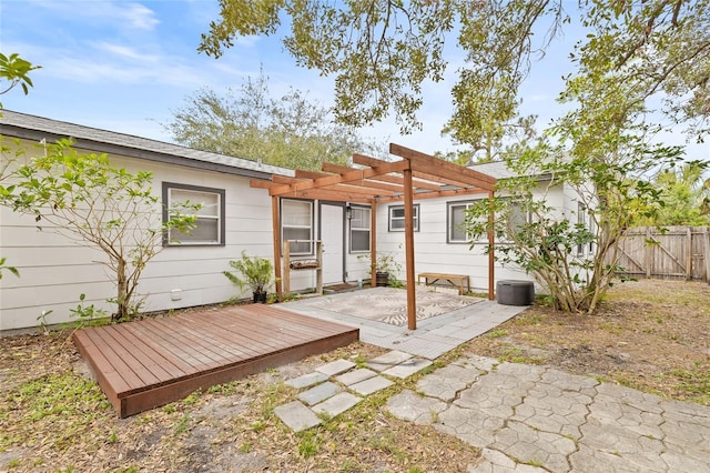 rear view of property featuring a pergola and a deck