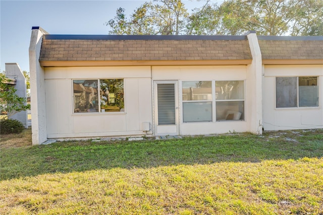 rear view of property with a lawn