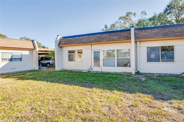 back of property featuring a lawn