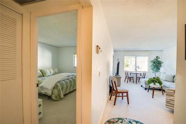 bedroom with a textured ceiling and light carpet