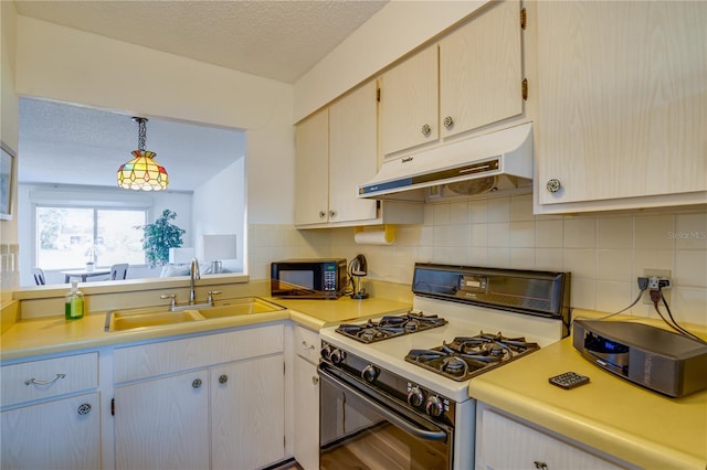 kitchen featuring tasteful backsplash, a textured ceiling, sink, white range with gas stovetop, and hanging light fixtures