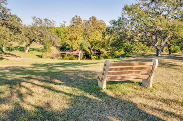 surrounding community featuring a water view and a lawn