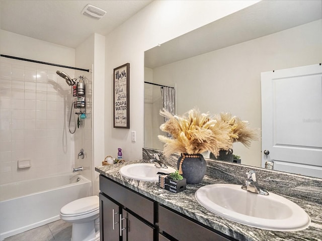 full bathroom with tiled shower / bath, vanity, tile patterned floors, and toilet