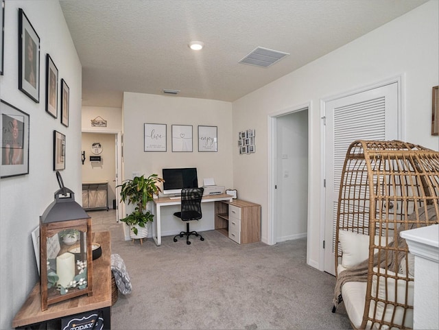 carpeted office with a textured ceiling