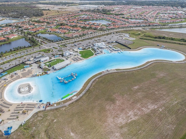 birds eye view of property with a water view and a beach view