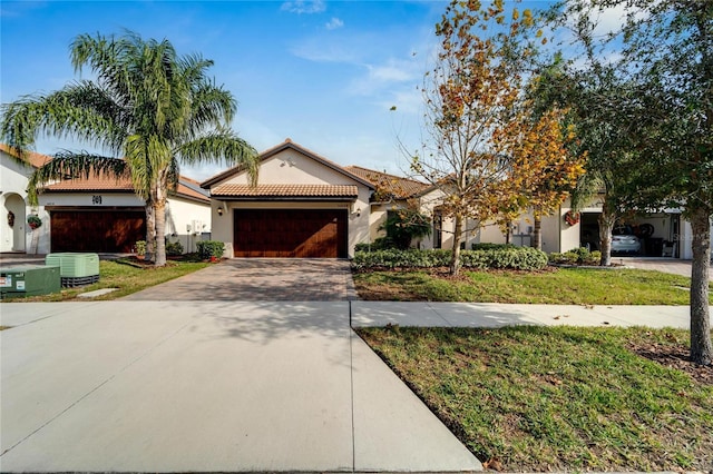 view of front of property with a garage, a front lawn, and cooling unit