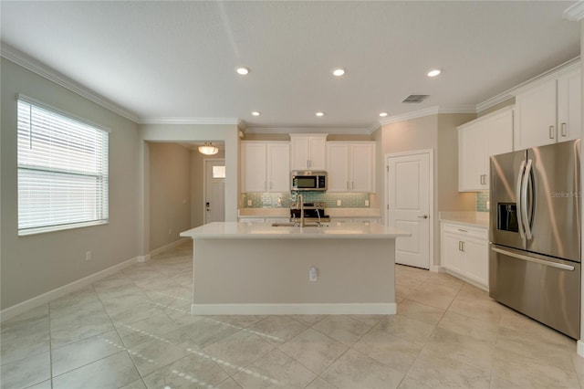 kitchen featuring sink, stainless steel appliances, backsplash, a kitchen island with sink, and white cabinets