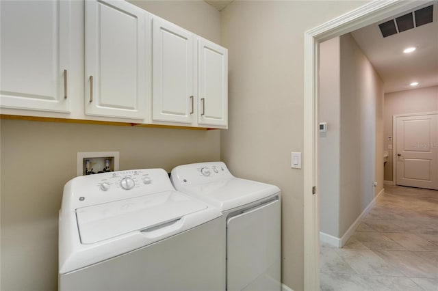 laundry area with cabinets, independent washer and dryer, and light tile patterned floors