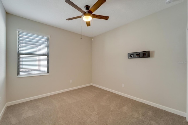 carpeted spare room featuring ceiling fan