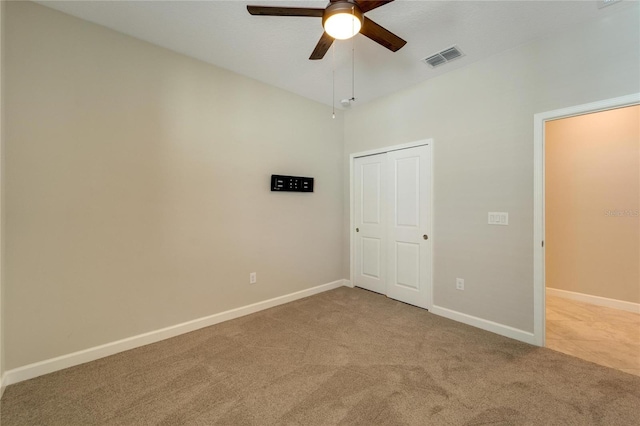 unfurnished bedroom with ceiling fan, a closet, and light carpet