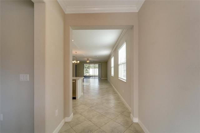 hall featuring light tile patterned floors, an inviting chandelier, and ornamental molding