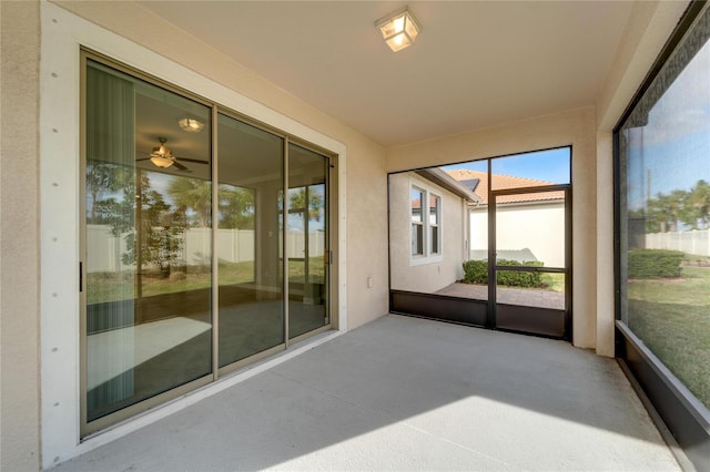 unfurnished sunroom with ceiling fan