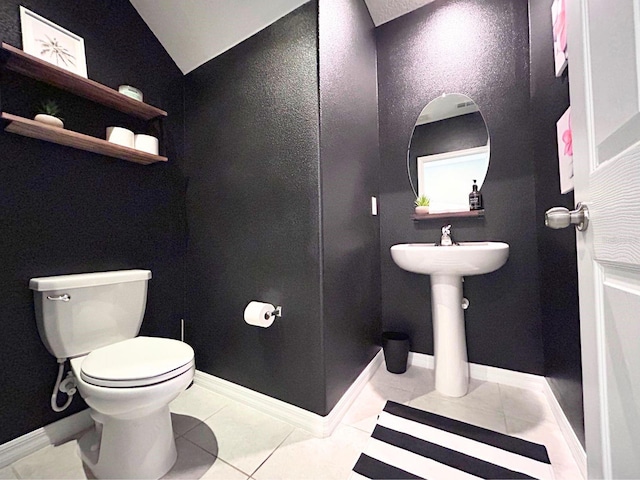 bathroom with sink, tile patterned flooring, vaulted ceiling, and toilet