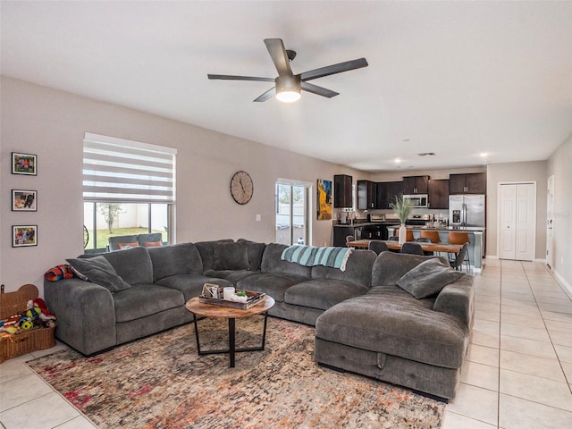 living room featuring ceiling fan, a healthy amount of sunlight, and light tile patterned floors