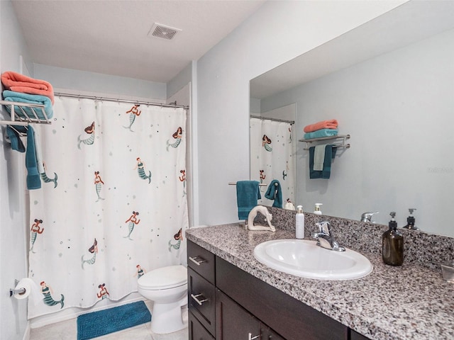 bathroom with tile patterned flooring, vanity, and toilet