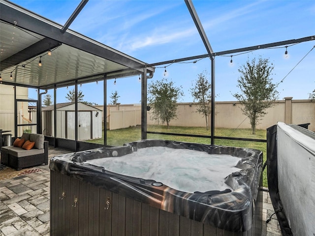 view of patio / terrace with a hot tub and a shed