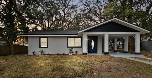 view of front facade with a carport and a lawn