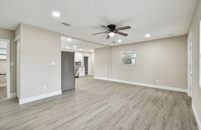 unfurnished living room featuring ceiling fan and light hardwood / wood-style flooring