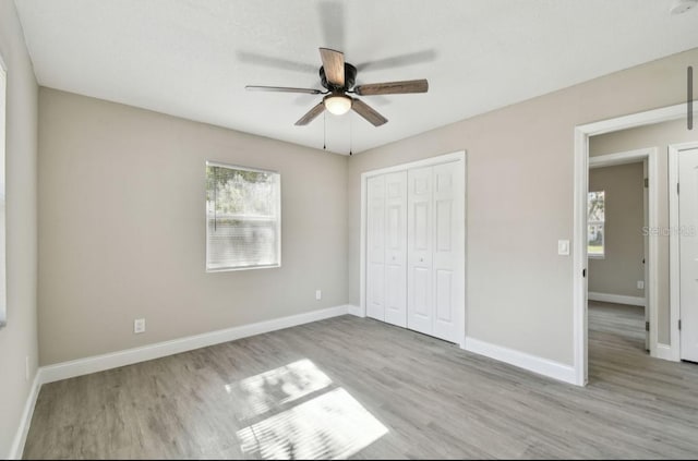 unfurnished bedroom with a closet, light hardwood / wood-style flooring, and ceiling fan