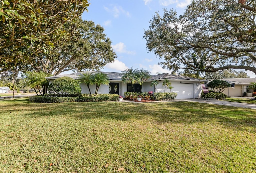 single story home featuring a front lawn and a garage