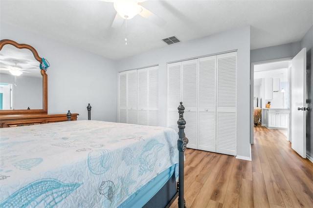 bedroom featuring multiple closets, ceiling fan, and light wood-type flooring