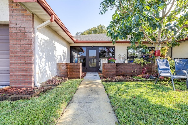 doorway to property with brick siding, a lawn, and stucco siding