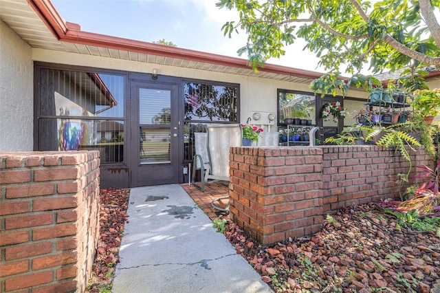 view of exterior entry featuring stucco siding