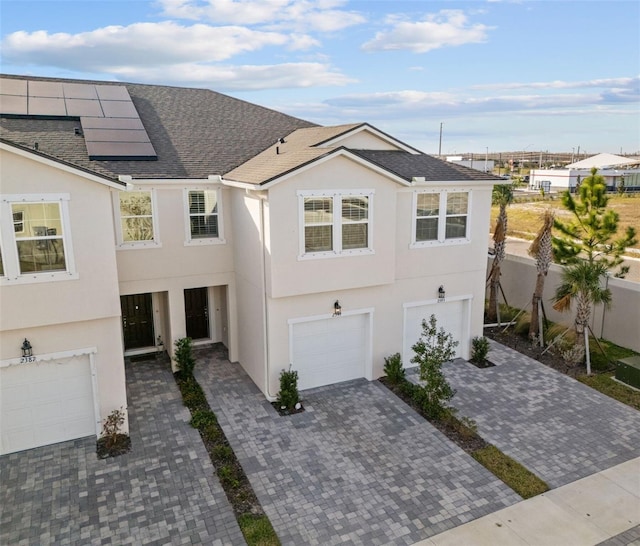 view of front of house featuring a garage and solar panels