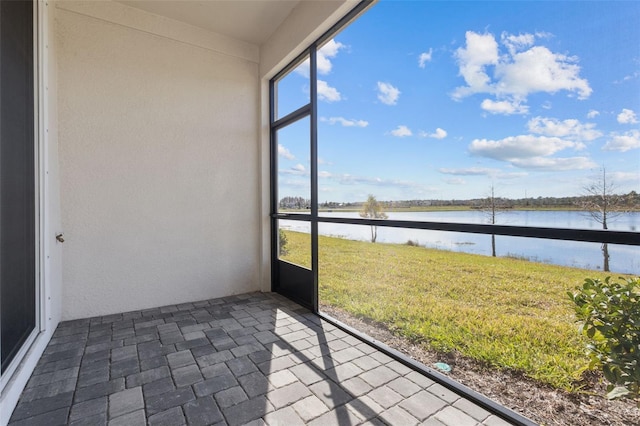 unfurnished sunroom with a water view