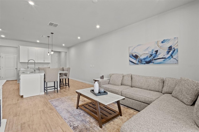 living room with light wood-type flooring and sink