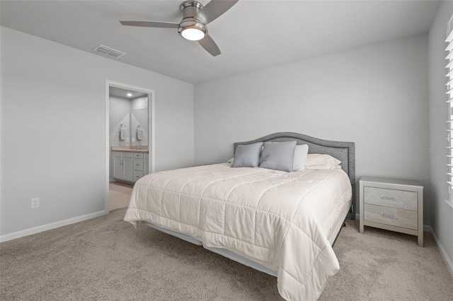 carpeted bedroom featuring ceiling fan and ensuite bath