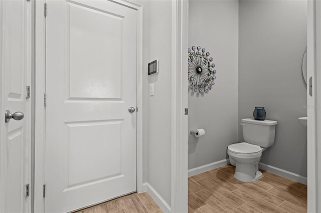 bathroom with toilet and wood-type flooring