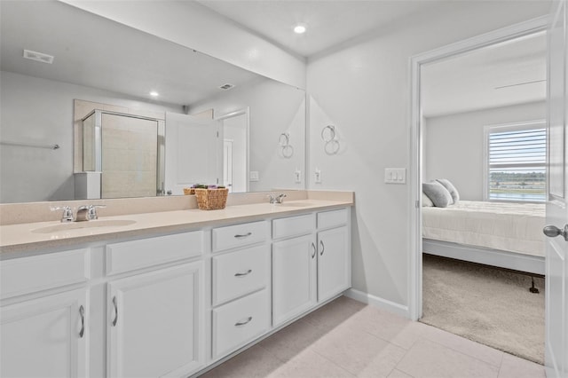 bathroom with vanity, a shower with shower door, and tile patterned floors