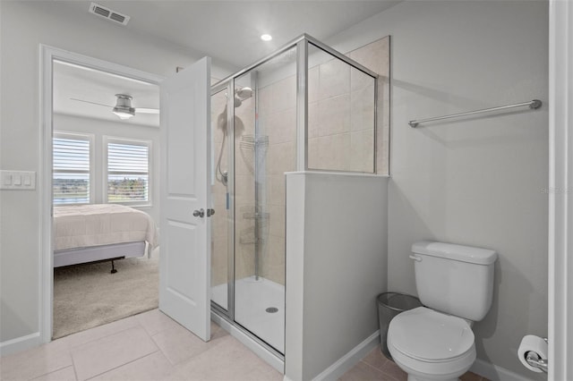 bathroom with a shower with door, toilet, and tile patterned floors