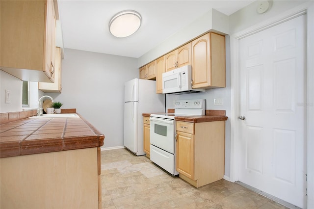 kitchen with white appliances, tile countertops, sink, and light brown cabinets