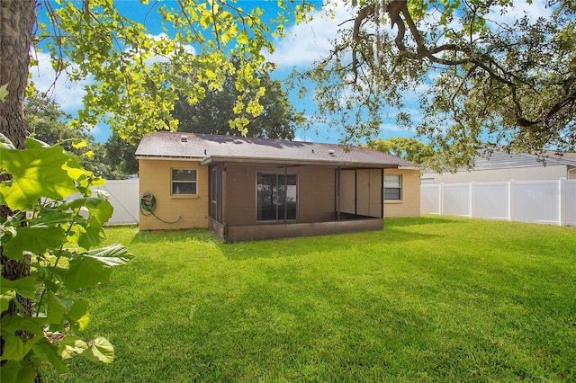 rear view of property featuring a lawn