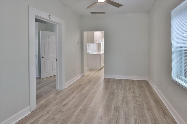 spare room with ceiling fan and light wood-type flooring