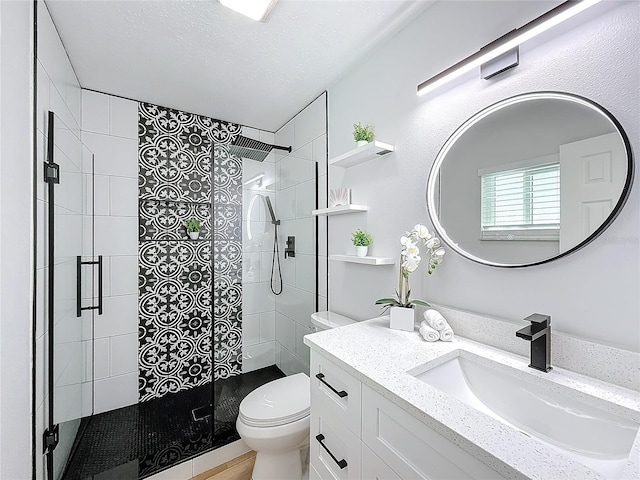 bathroom with vanity, a shower with shower door, and toilet