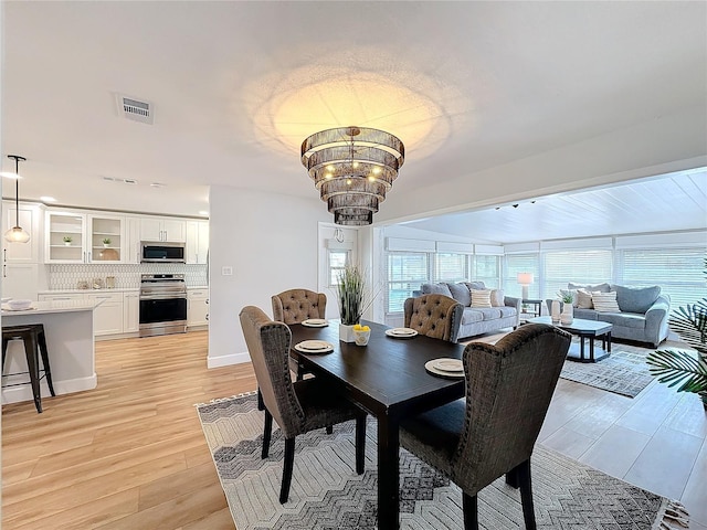 dining space featuring a chandelier, light hardwood / wood-style flooring, and plenty of natural light