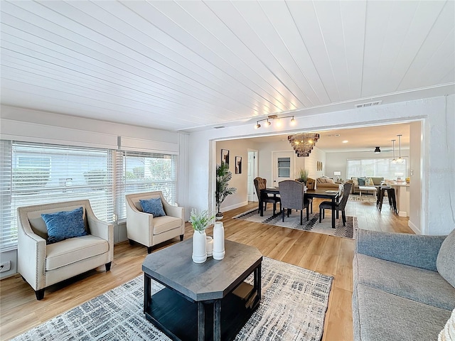 living room with track lighting, wood-type flooring, wooden ceiling, and a chandelier