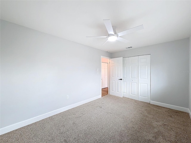 unfurnished bedroom with ceiling fan, a closet, and carpet floors