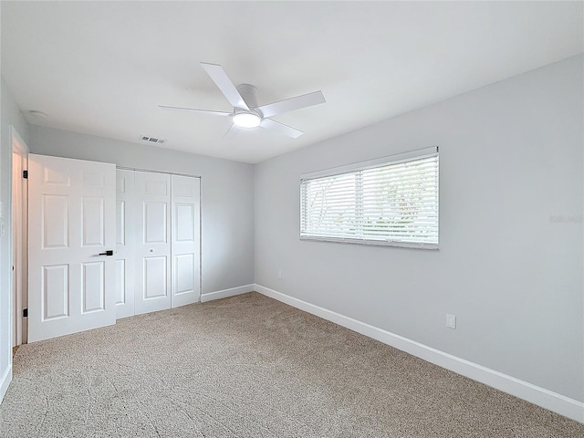 unfurnished bedroom featuring carpet flooring, ceiling fan, and a closet