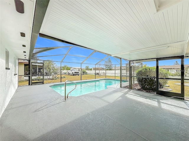 view of swimming pool with glass enclosure, a yard, and a patio