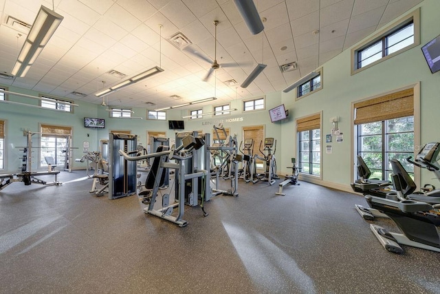 exercise room featuring a towering ceiling