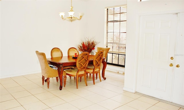 tiled dining room featuring a chandelier