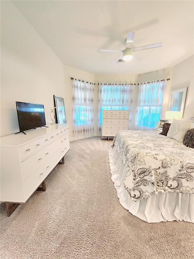 carpeted bedroom with multiple windows and ceiling fan