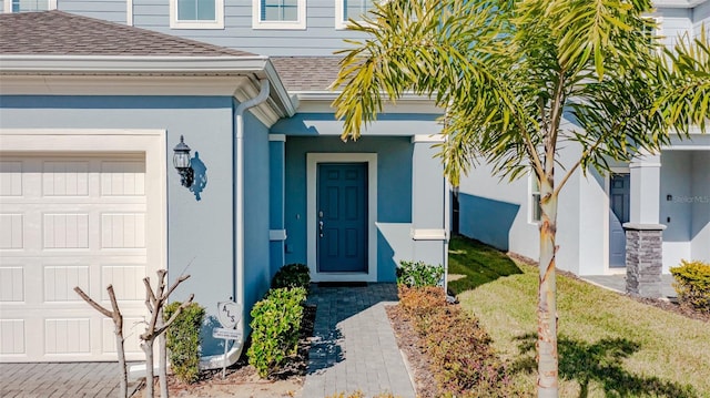 1166 Aloha Blvd, Davenport, FL 33897 - doorway to property featuring a shingled roof, an attached garage, and stucco siding