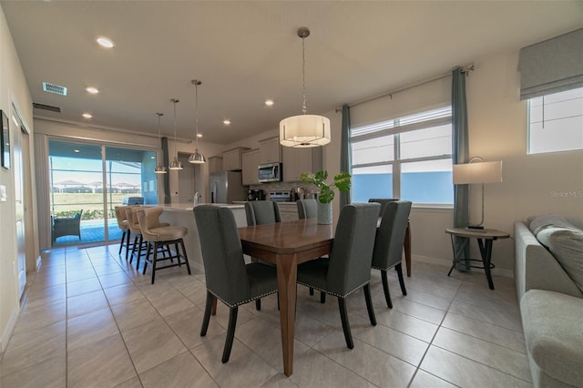 dining room with light tile patterned floors and a healthy amount of sunlight